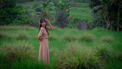 Asian woman do solo traveling to a rice field, enjoying the scenery and fresh air in the village.