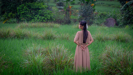 Asian woman do solo traveling to a rice field, enjoying the scenery and fresh air in the village.