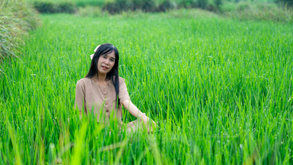 Asian woman do solo traveling to a rice field, enjoying the scenery and fresh air in the village.