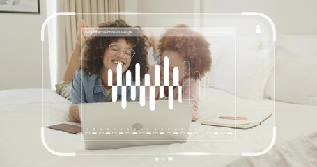 Lying two friends watching laptop in bedroom, with notebook, eyeglasses, waveform overlay