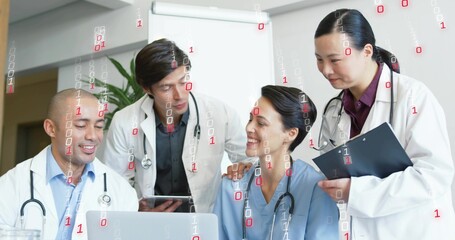Reviewing medical team in lab coats and blue scrubs analyzing laptop data at clinic, with tablet
