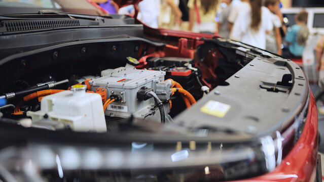 Electric vehicle engine bay revealing power components at an automotive exhibition