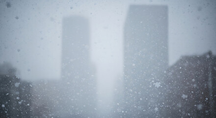 Snow falls heavily in urban cityscape, creating a serene and atmospheric winter scene with blurred buildings in the distance, showcasing the beauty of nature's touch.