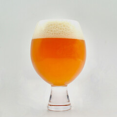 A beer in a goblet style glass against a white background. 