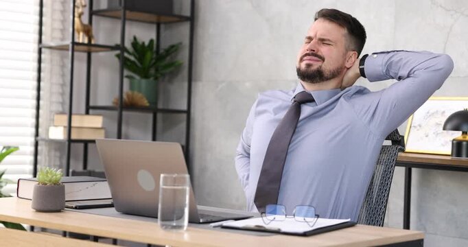 Man feeling fatigue at wooden desk in office