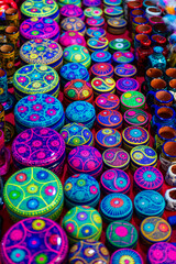 Fototapeta premium A colorful display of round trinket boxes with intricate floral and yin yang inspired patterns at a local craft market