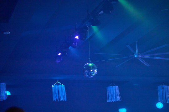 Nightlife dancing people backlit by neon lights on dance floor