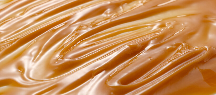 Full frame close-up texture background of thick golden Manuka honey.
