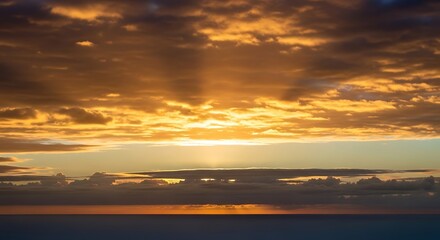 Fototapeta premium Vibrant sunset over a serene landscape with radiant sunlight filtering through clouds