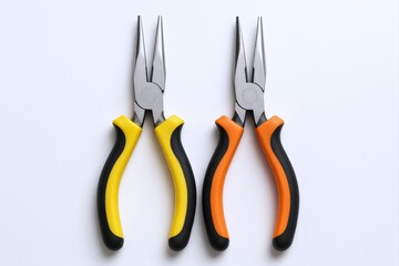Obraz premium Two needle-nose pliers with yellow and orange grips, arranged symmetrically on a white surface