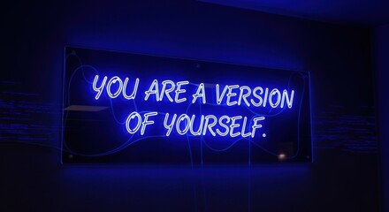 Fototapeta premium Blue Neon Sign Reads 'You Are A Version Of Yourself' On Dark Wall