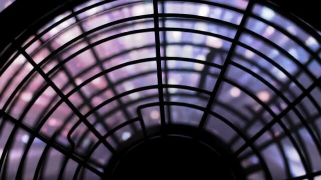 Abstract dark fan grill with bokeh background for cooling and ventilation.
