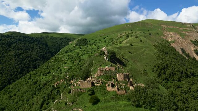 Drone aerial view of the abandoned mountain village of Gamsutl in Dagestan at sunrise with soft morning light and dramatic scenery.
