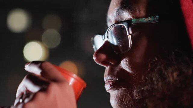 bearded man sipping hot drink during latenight stargazing, amateur astronomer warming hands, eyeglasses fogged, city lights bokeh, closeup profile shot conveying contemplative mood and quiet