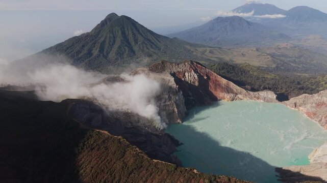 Aerial Pan Over Ijen Volcano Crater Lake with Turquoise Acid Water and Sulfur Smoke, East Java, Indonesia.