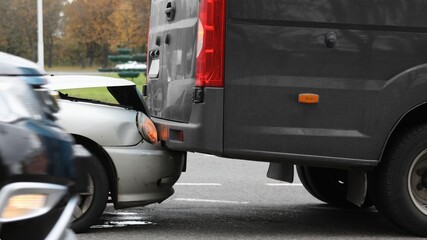 Rear-end collision between a silver car and a black van on city street. Traffic crash. © Sahrul