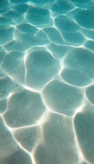 Clear aqua water ripples with sunlight creating abstract patterns on sandy seabed. Calm ocean surface texture evokes summer peace and relaxation. Refreshing nature scene.