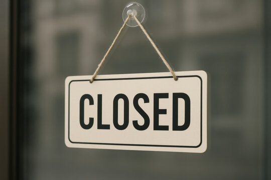 Closed sign hanging on glass door with suction cup and rope