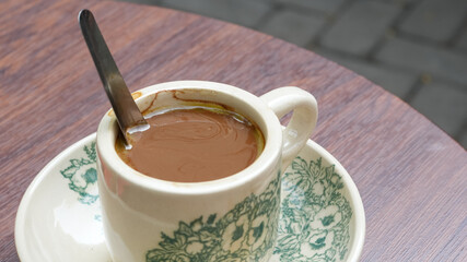 Traditional coffee cup on a saucer, placed on a wooden table