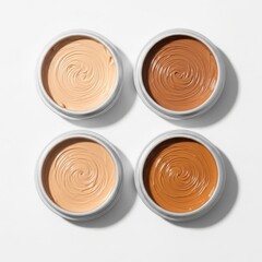Four different shades of foundation makeup isolated on white background