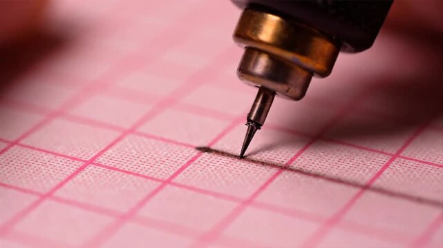 Close-up view of ecg machine stylus tracing on graph paper with precise measurements