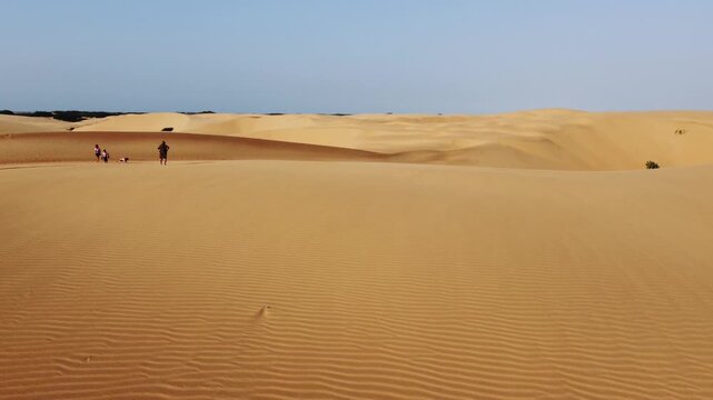 Personas en medanos parecido al desierto ubicado en coro estado Falcon Venezuela. Su arena dorada en el atardecer junto con la brisa genera textura en el suelo