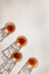 Whiskey Glasses with Shadows and sunlight Reflection on beige background, minimal aesthetic top view summer still life, refraction throug crystal shine cups, caustics effect, vertical