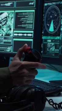 Soldier in a dimly lit military control room, intensely focused on multiple computer screens displaying crucial operational drone data.