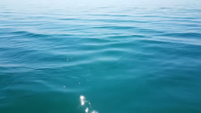 Seamless loop of a perfectly still turquoise lake surface with gentle, repeating wavelets creating a therapeutic and minimalist motion background blue, nature, pattern