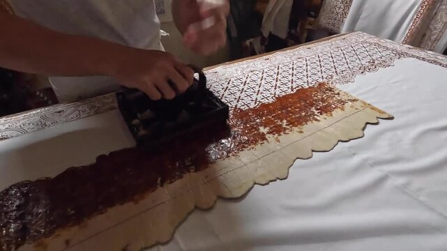Hand printing batik with traditional wax stamps dipped in hot wax on white Ccotton fabric, Indonesian textile craft process in 4K