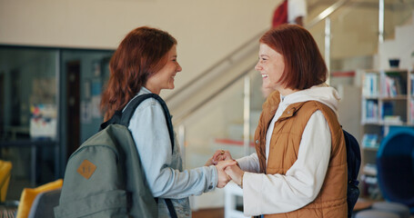 Obraz premium Education, greeting and holding hands with girl friends on high school campus for development. Excited, learning and smile of teen students in hallway together for academic future, bonding or study