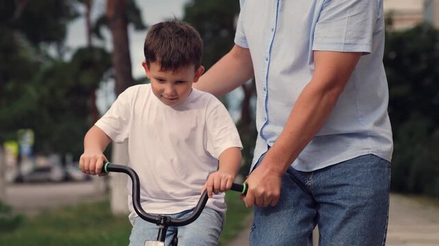 father teaches child ride bike, boy laughs smiling sitting bike outdoors, horse riding, boy laugh smile face, child riding bike, boy brown hair, child boy toothless smile, kid dental surgery, loss