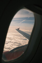 Fototapeta premium Airplane Wing Above Clouds at Sunrise – Aerial View from Window, Scenic Travel Flight Landscape