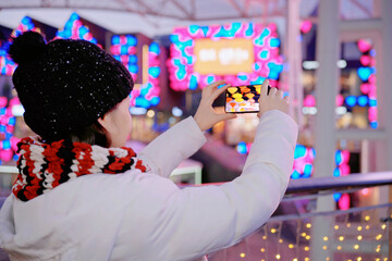 Woman Taking Photo of Colorful Festival Lights