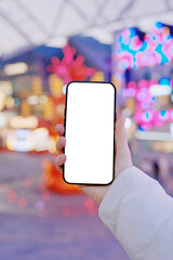 Hand Holding Smartphone with Blank Screen in Festival Night