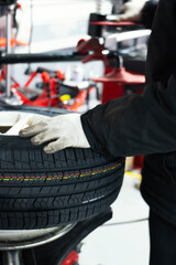 Auto Mechanic Handling Tire in Workshop