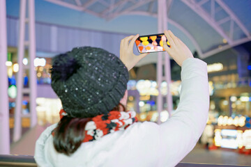 Woman Taking Photo of Night Scene with Smartphone
