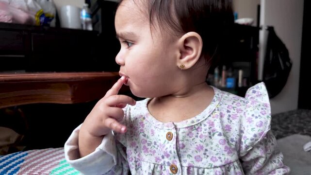 Adorable One-Year-Old South Asian Baby Girl Eating Food With Her Hand Demonstrating Early Childhood Development And Self-Feeding Skills In A Home Settings