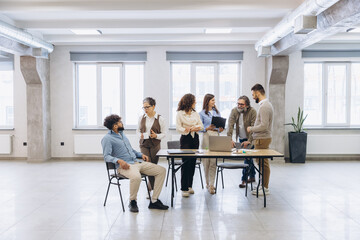 Fototapeta premium Diverse business team collaborating during an office meeting, brainstorming ideas and analyzing data with laptops