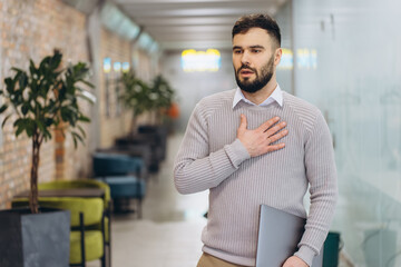 Obraz premium Employee feeling chest pain and shortness of breath, having a panic attack or heart attack while working in office