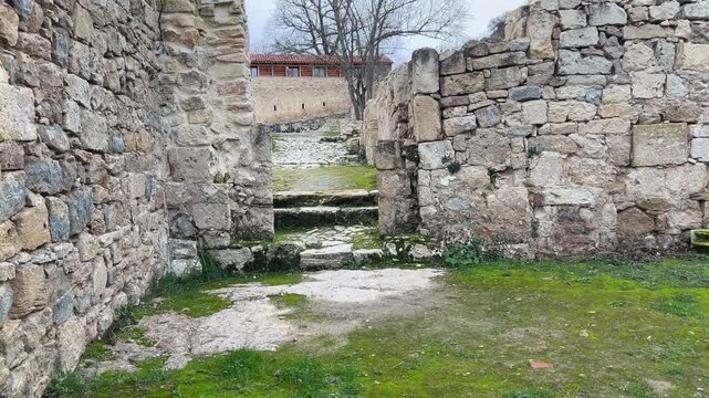 POV subiendo dos escalones de piedra entre ruinas en Monasterio de Rioseco