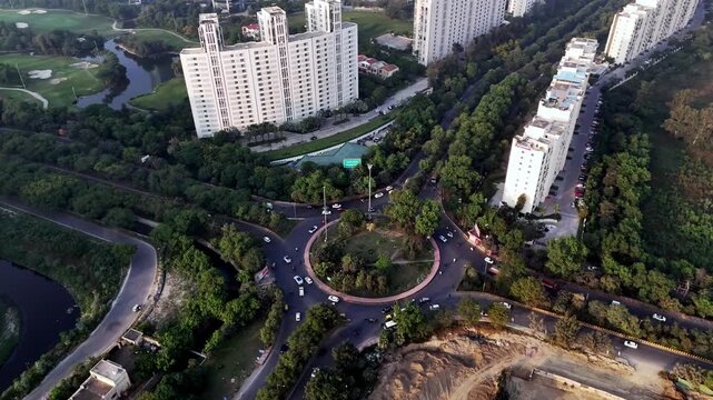 Wide aerial perspective of Pari Chowk with its central circular junction, expansive boulevards, and dense greenery, symbolizing the gateway and urban heart of Greater Noida.