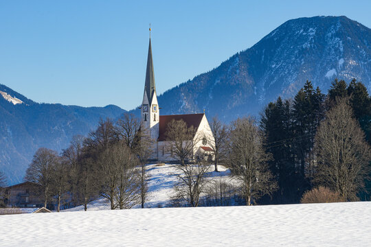 The Roman Catholic parish church of the Assumption of Mary in Bad Wiessee on Lake Tegernsee in the Bavarian Alps. Idyllic winter landscape framed by the Tegernsee mountains