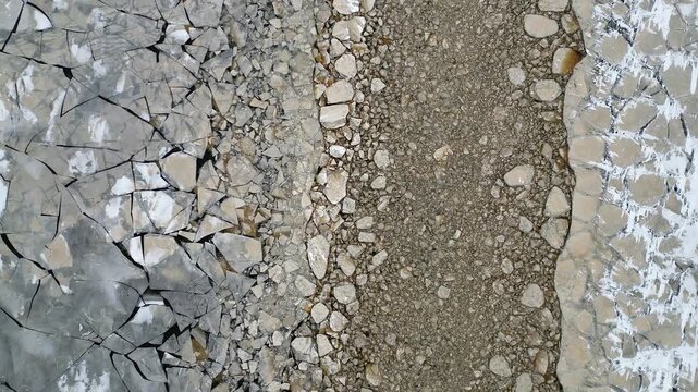 Fractured sea ice and rocky shoreline create winter nature patterns
