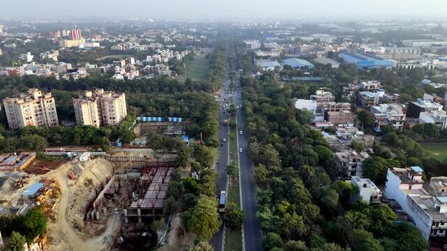 Drone footage of Greater Noida streets framed by dense greenery, intersecting roads, and moving vehicles, highlighting balanced urban planning and connectivity.