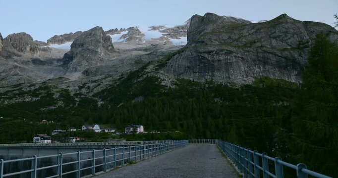 Scenic view of Fedaia Pass dam, majestic Marmolada mountain and its glacier at dusk in the Italian Dolomites, Italy