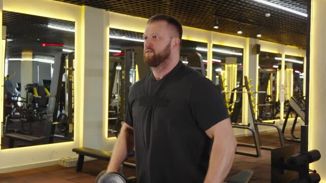 Athlete doing lateral raises with dumbbells in studio