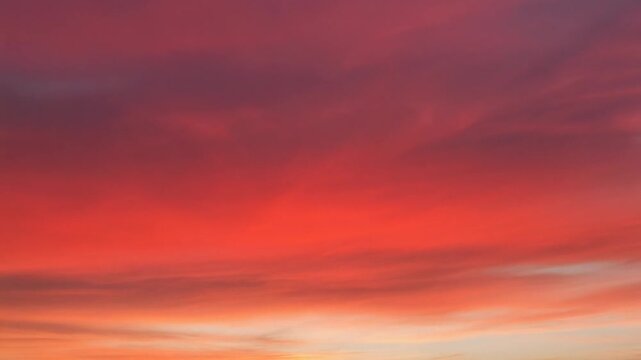 Vibrant orange and red sunset sky with wispy clouds