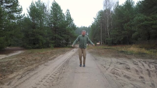 Man jumping rope on forest road during outdoor workout, Cardio training improving endurance coordination agility and overall physical fitness