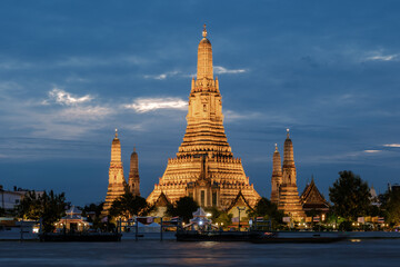 Naklejka premium Stunning Wat Arun Temple illuminated at dusk in Bangkok, Thailand, a traveler's paradise